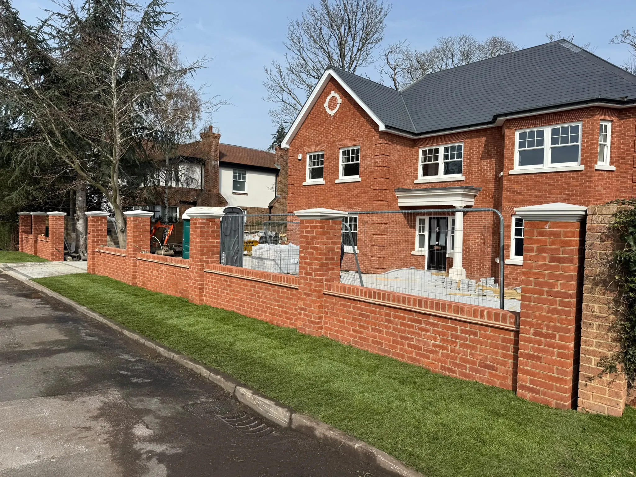 Red brick front boundary wall with piers to a large home by Prestige Landscapes