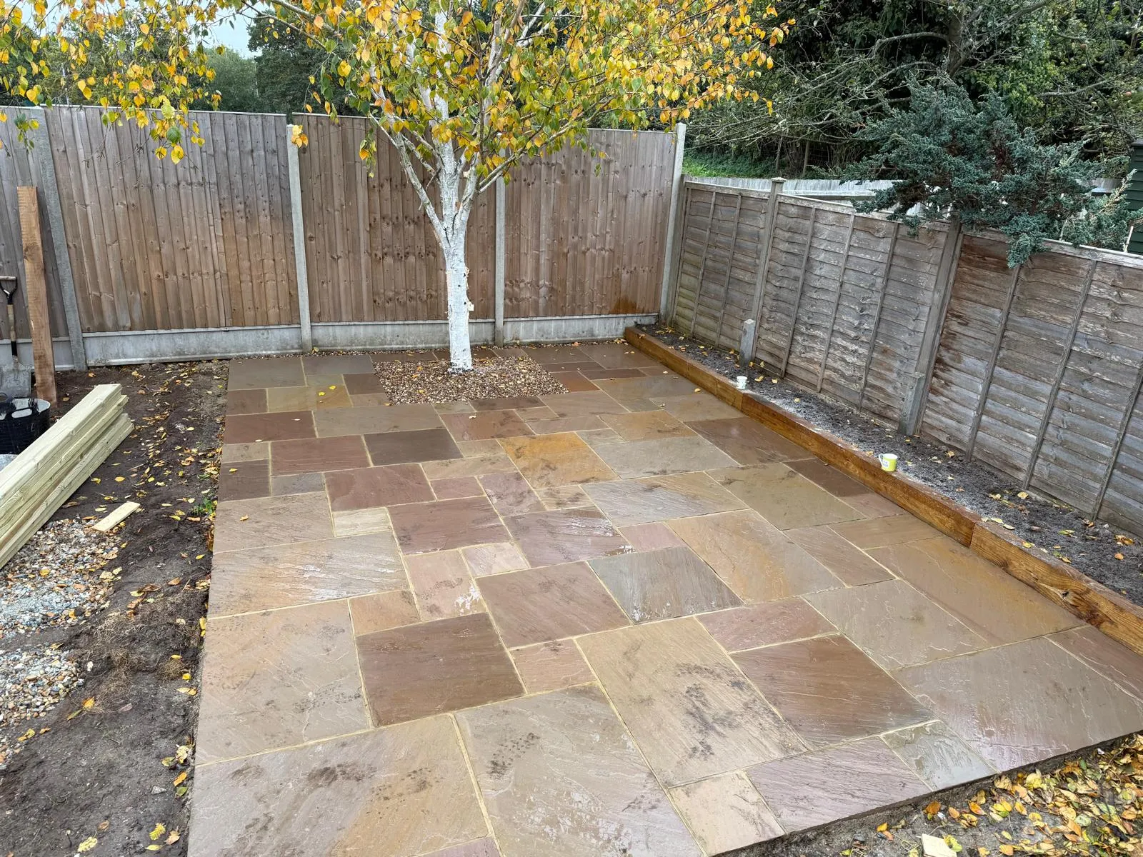 Indian sandstone patio with silver birch feature bed by Prestige Landscapes